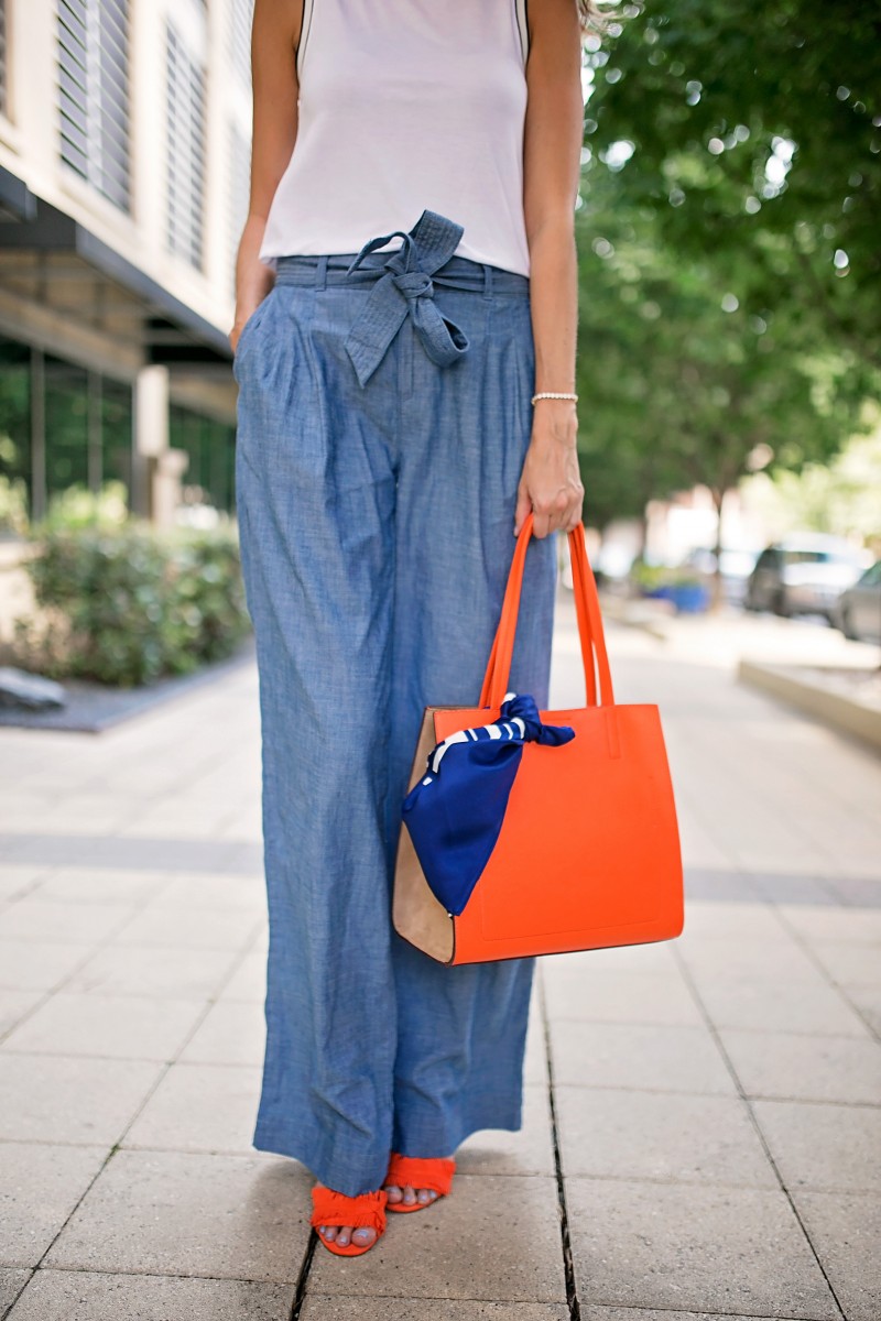 The Miller Affect wearing wide leg chambray pants and an orange tote