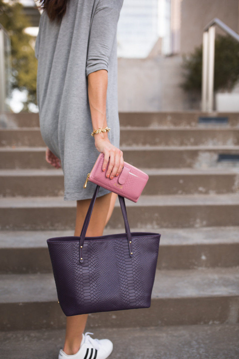 The Miller Affect holding a pink embossed leather wallet and a purple embossed leather tote