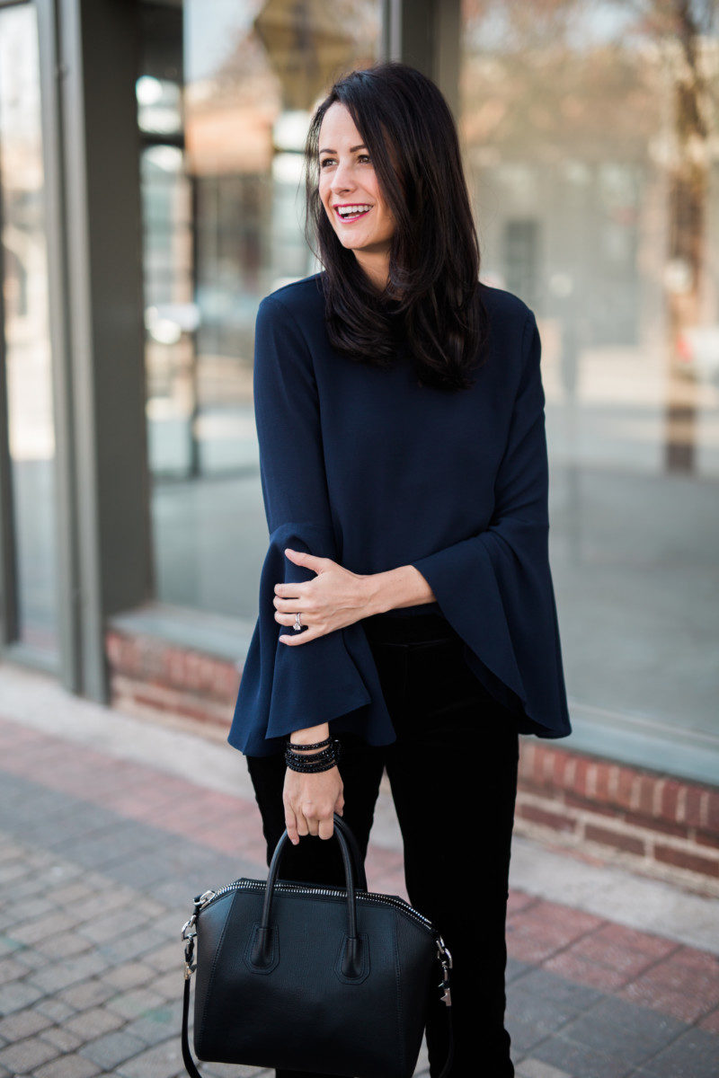 The Miller Affect wearing Navy bell sleeve top and black Victoria Emerson bracelet