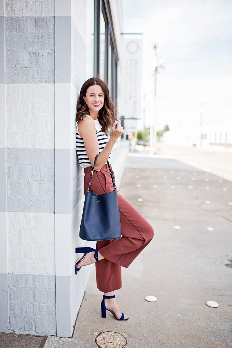 The Miller Affect wearing a navy striped top and tall piped fluid ankle pants with navy blue Leda Block Heel Sandals