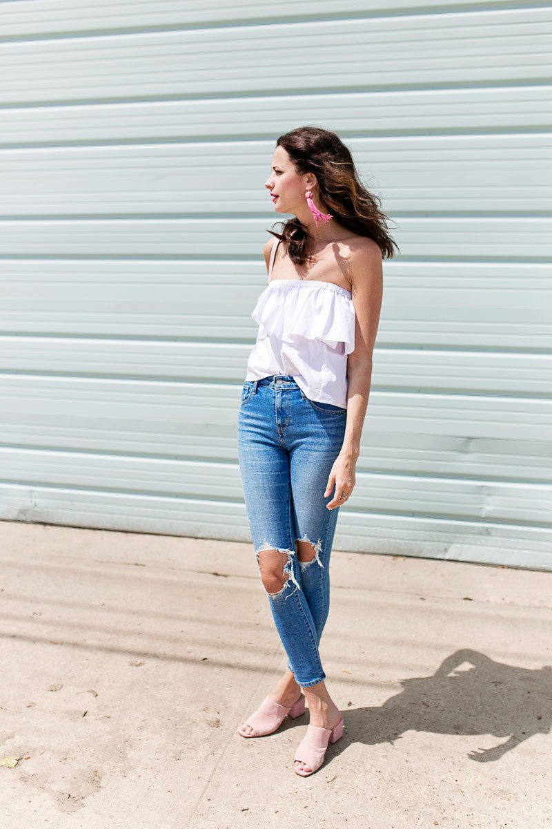 Amanda Miller wearing a white off the shoulder top and high rise distressed skinny jeans