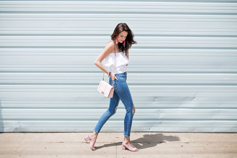 Amanda Miller wearing a white off the shoudler top and high rise skinny jeans under $100