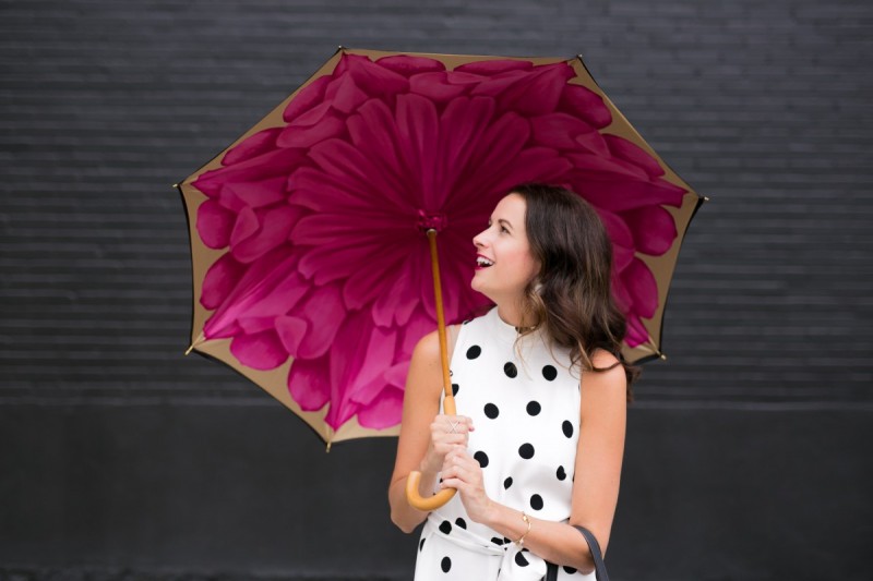 Amanda Miller looking at a pink and black floral umbrella made by Brellini in Italy