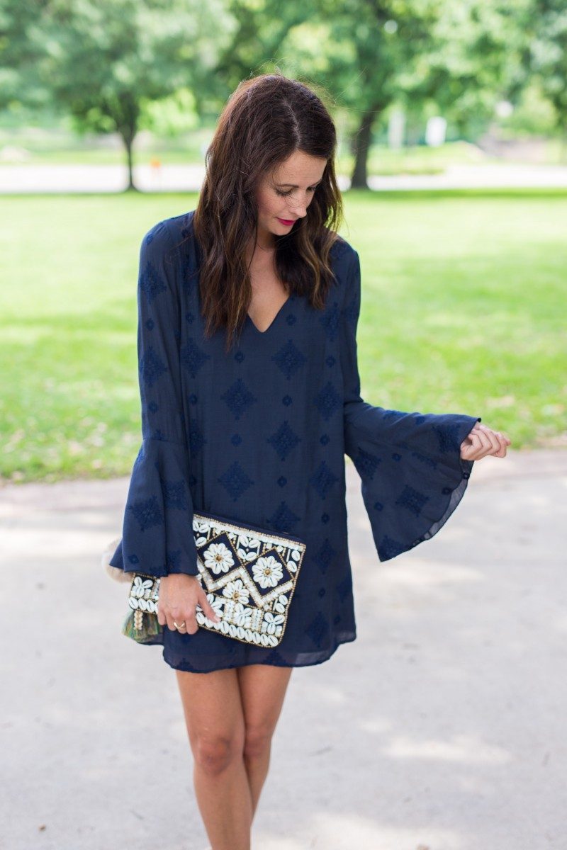 The Miller Affect wearing a navy blue embroidered bell sleeve blouse from WAYF
