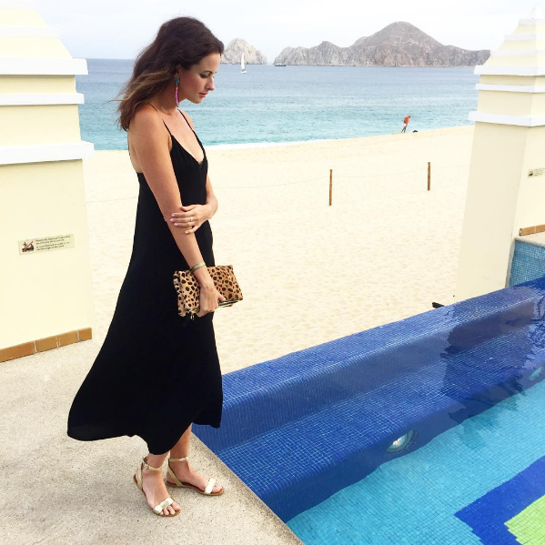 The Miller Affect wearing black hi low maxi dress with a leopard clutcj