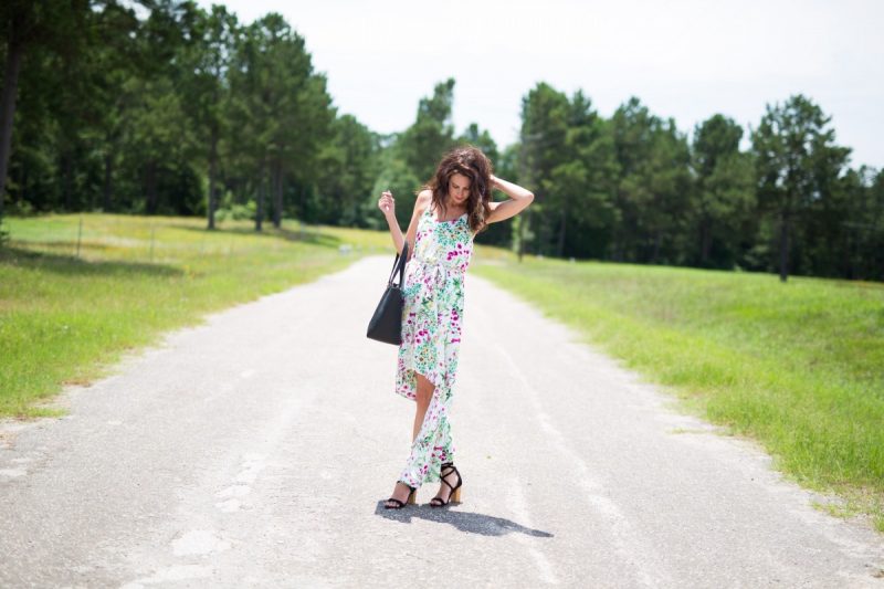 The Miller Affect wearing a black kate spade tote, black lace up heels, and a white floral dress