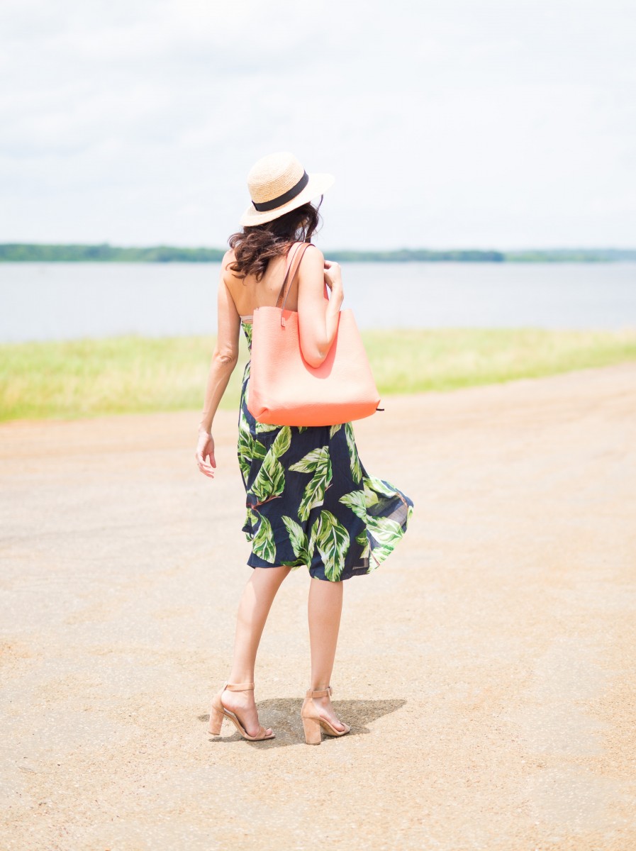 Amanda Miller wearing a coral reversible tote and a straw boater hat