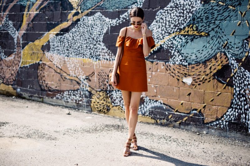The Miller Affect wearing an off-the-shoulder rust colored dress from Nordstrom