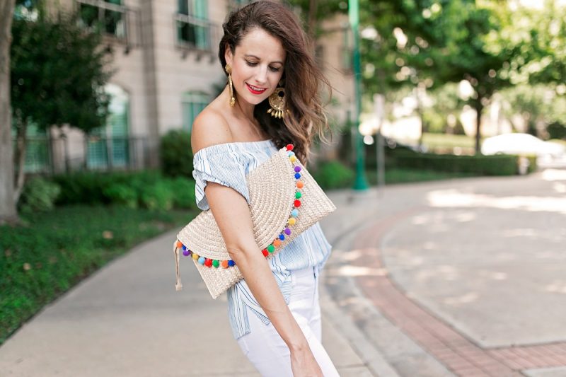 The Miller Affect wearing long white jeans and a Straw Pom Pom Trim Clutch