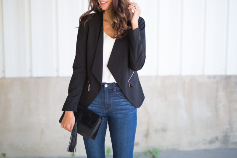 The Miller Affect wearing high-waisted dark wash jeans, a white cami, and a black vince camuto blazer from Nordstrom