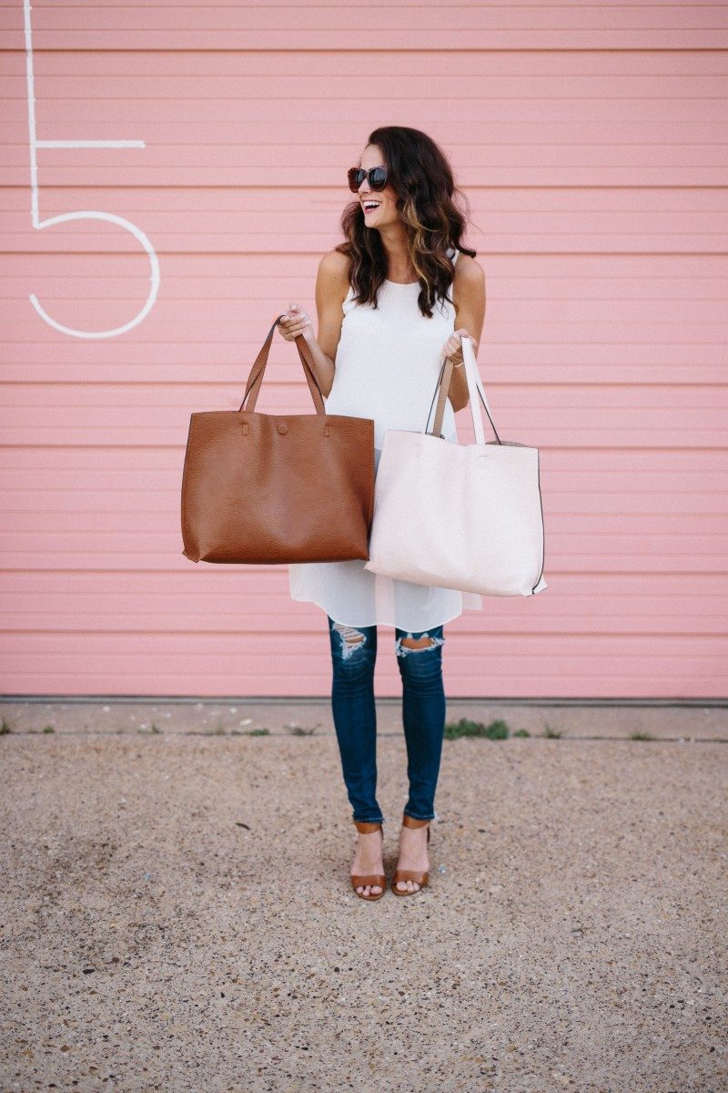 The Miller Affect holding up a cognac and pink reversible tote- both under $50
