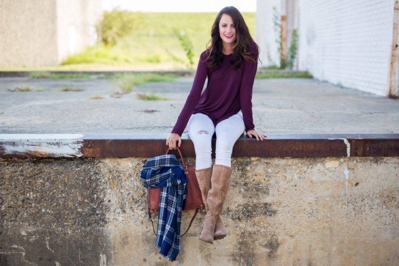 The Miller Affect wearing a burgundy tunic, white distressed jeans, and chestnut boots