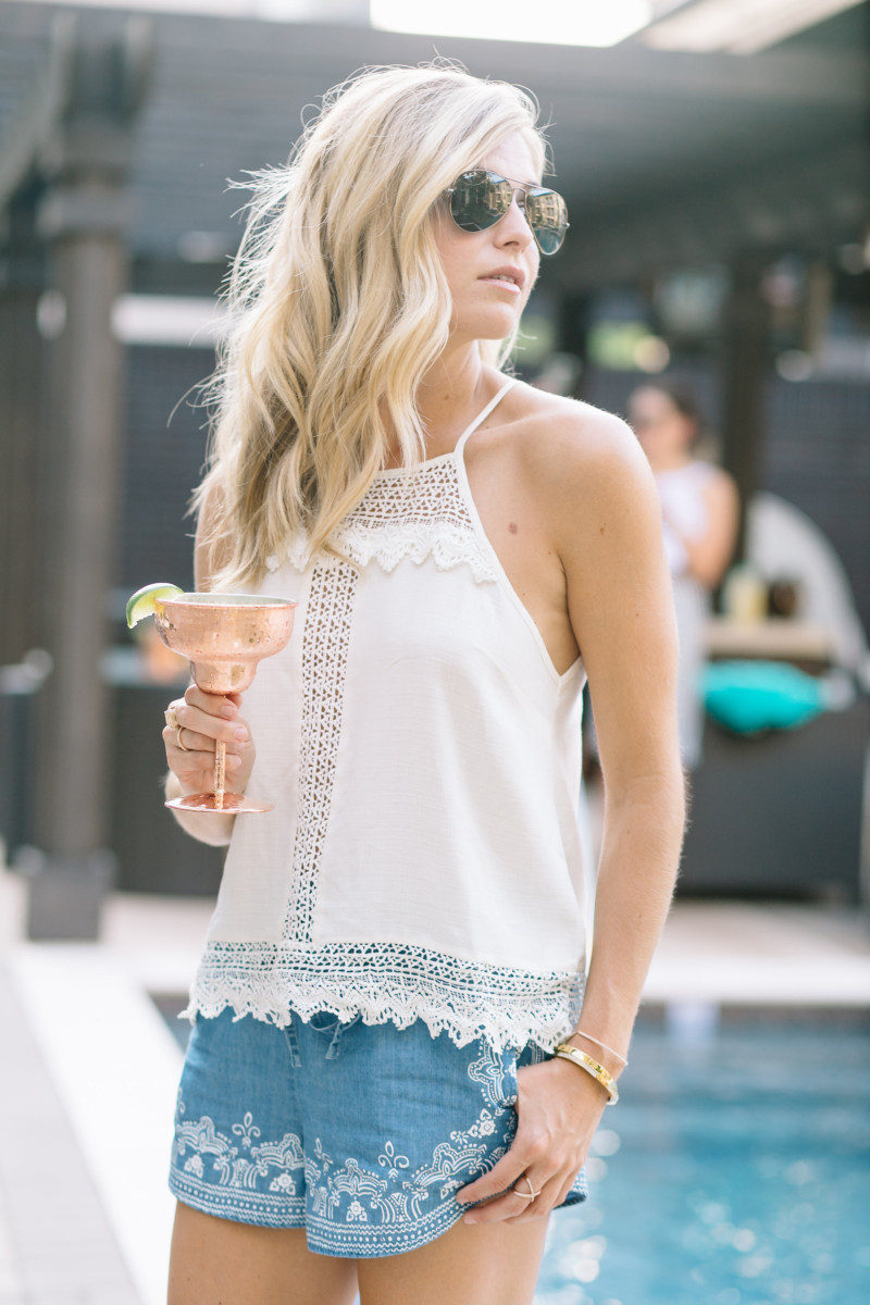 One Small Blonde wearing blue embroidered shorts and a white lace top