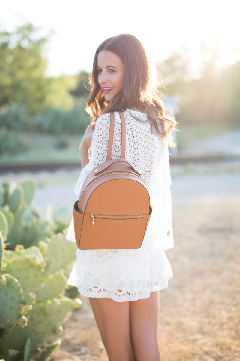 Amanda Miller wearing a cognac backpack and a white two piece eyelet set