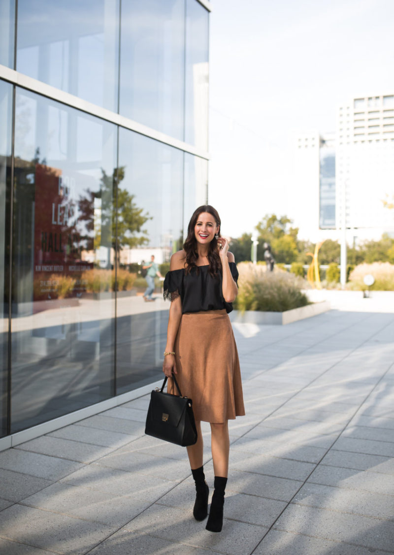 The Miller Affect wearing a black top and tan suede skirt for Fall