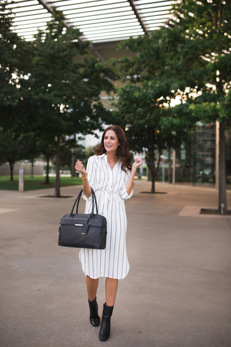 The Miller Affect in a striped shirt dress and carrying a black tote