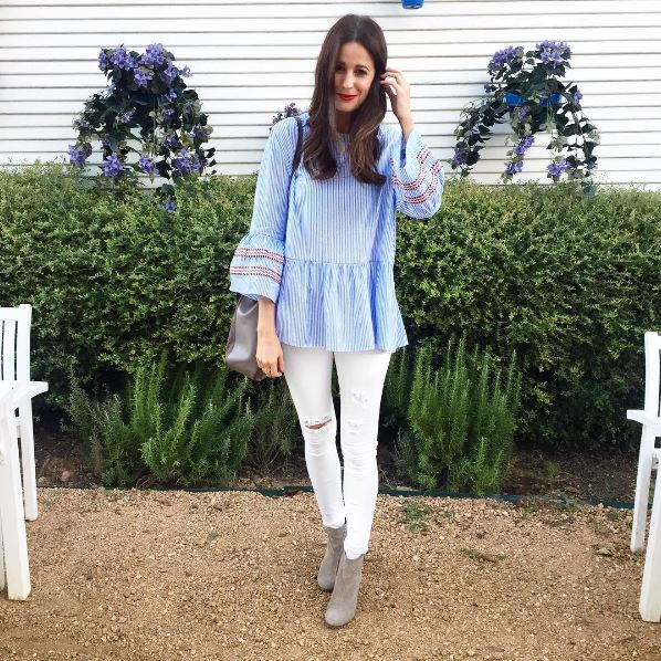 The Miller Affect wearing an oversized blue and white striped bell-sleeved blouse from Chicwish, white distressed jeans, and taupe Tom's Lunata booties