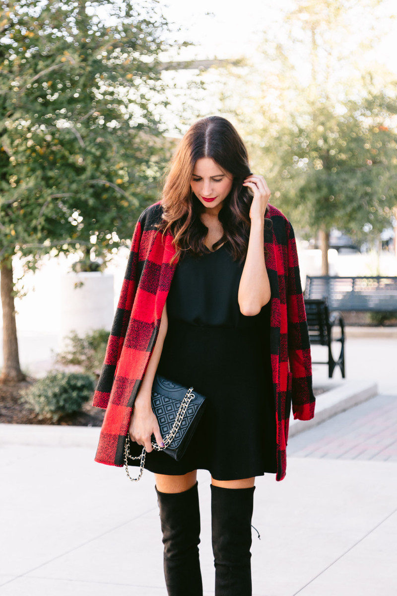 The Miller Affect wearing a plaid coat with a black flare skirt and black over the knee boots