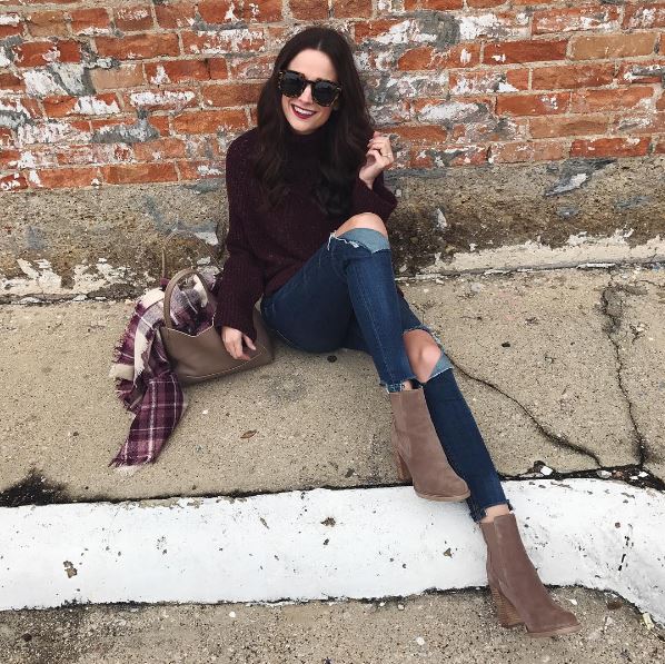 The Miller Affect wearing a burgundy mock neck sweater under $40 with distressed jeans and tan suede booties