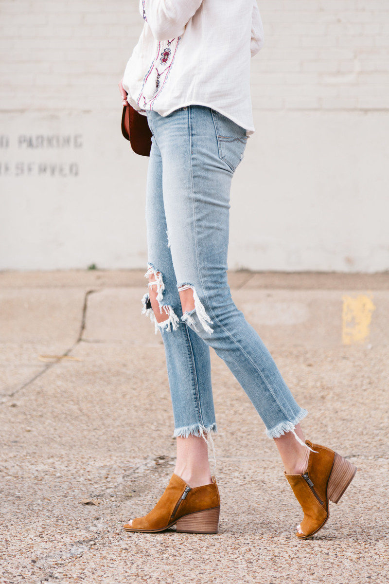 Amanda Miller wearing distressed jeans and tan suede booties
