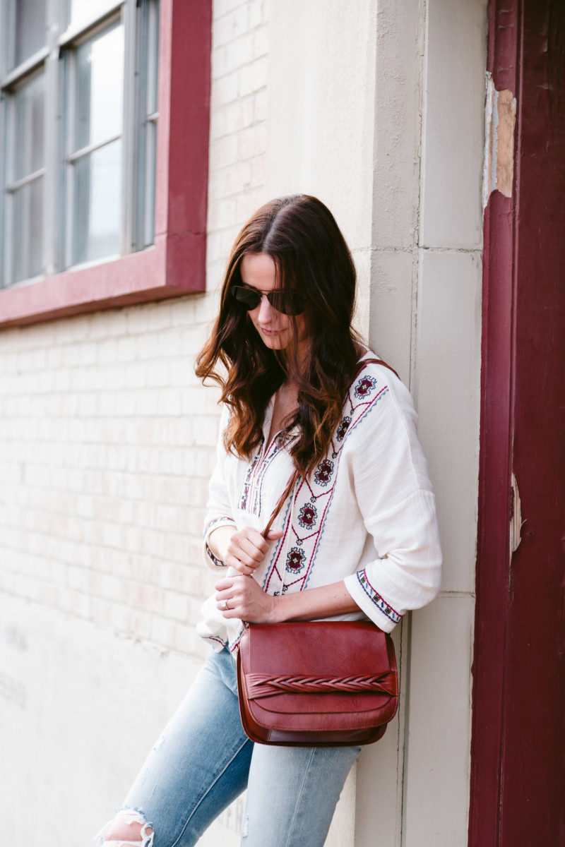 The Miller Affect wearing a brown leather braided purse from Lucky Brand