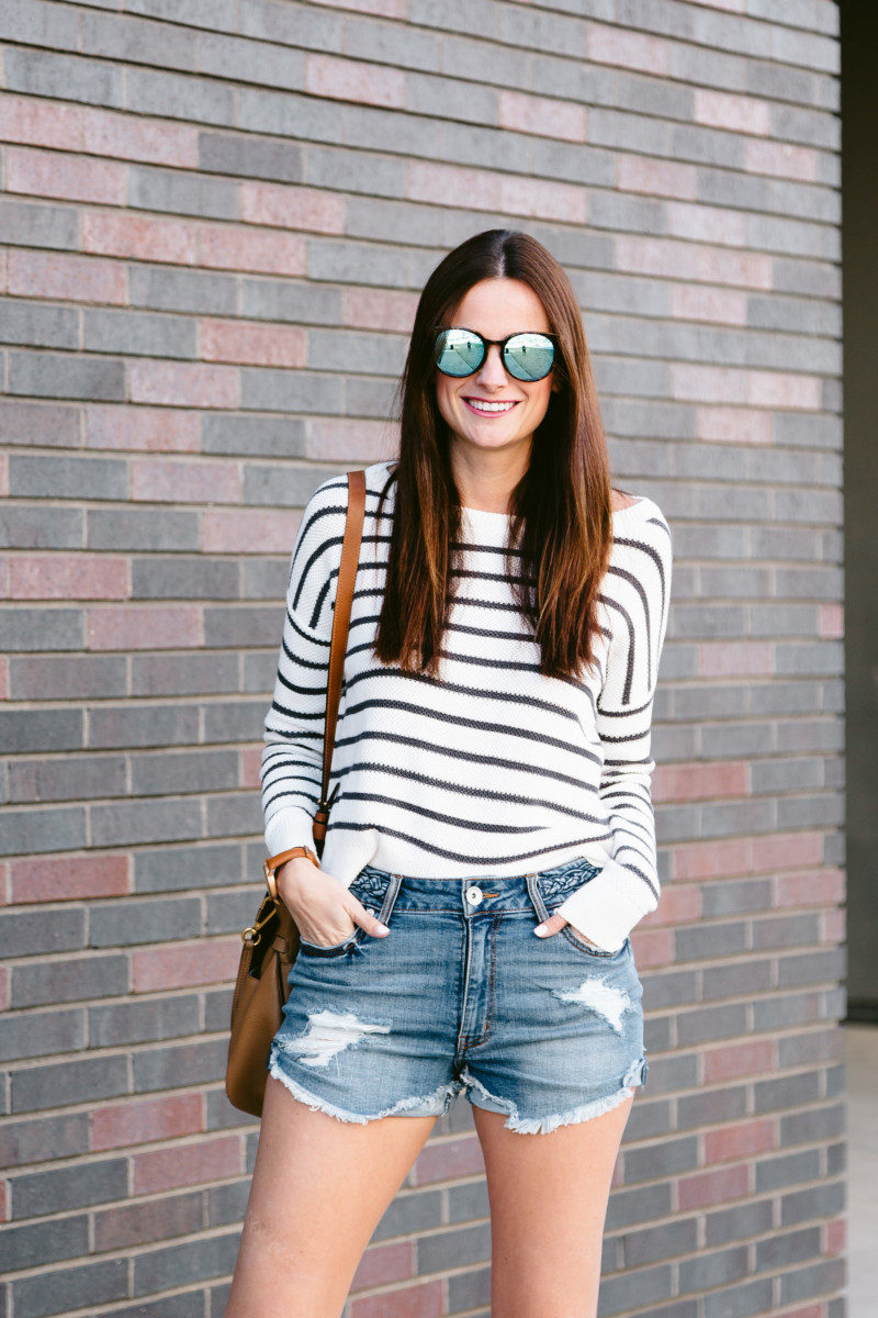 The Miller Affect wearing blue mirrored sunglasses and a long sleeve stripe top with an open back