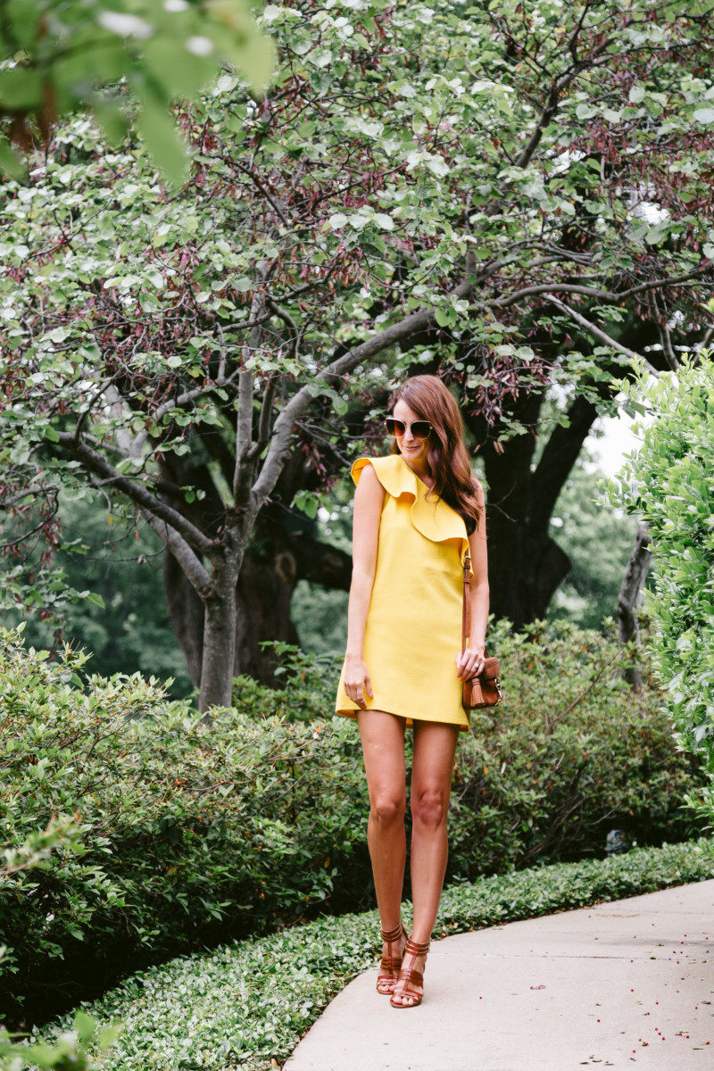 The Miller affect wearing a yellow one shoulder dress from cupcakes and cashmere