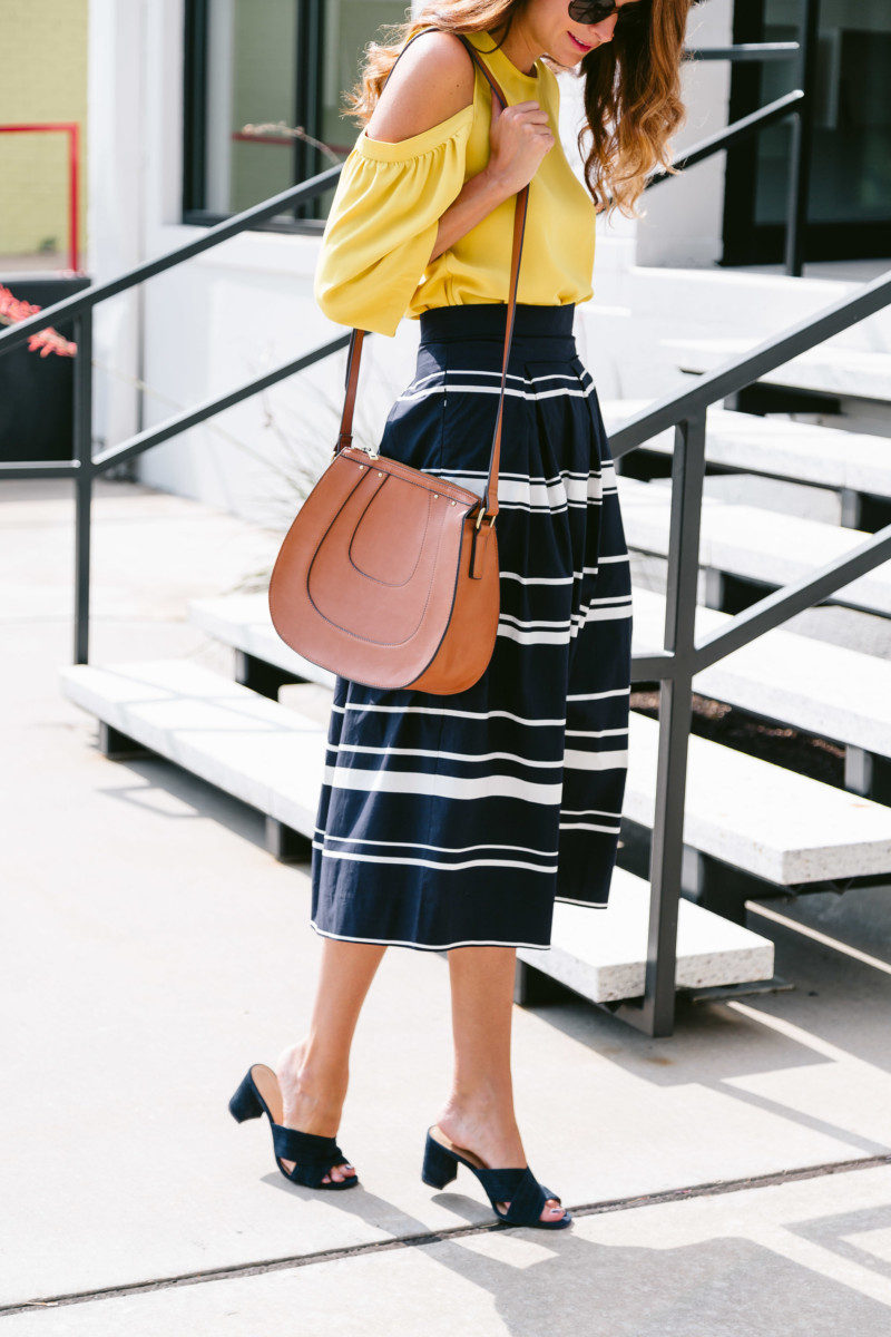 The Miller Affect wearing a cognac saddle bag and navy mules from Ann Taylor