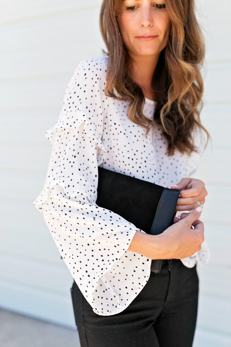 The Miller Affect wearing a polka dot ruffle blouse and holding a black sole society clutch from the Nordstrom Anniversary Sale