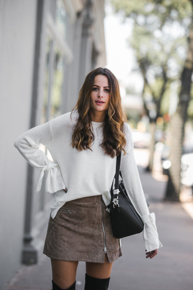 The Miller Affect wearing an ivory tie sleeve sweater with a tan suede miniskirt