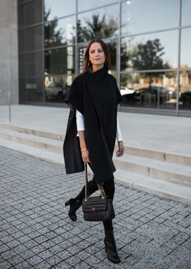 The Miller Affect wearing a black wool reversible cape from Henri Bendel