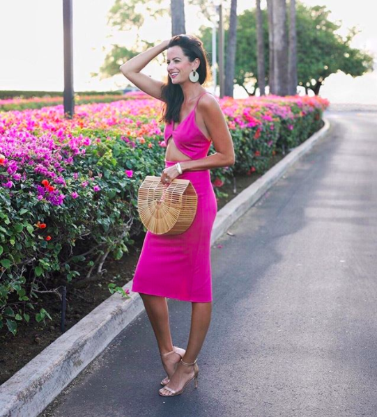 the miller affect wearing a hot pink midi dress with kendra scott earrings