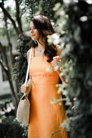 the miller affect wearing an orange square neck sheath dress from Ann Taylor