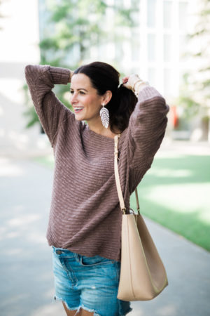 the miller affect wearing a mauve free people tunic sweater