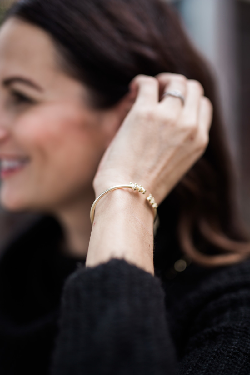 the miller affect wearing a gold cuff bracelet from Kendra Scott