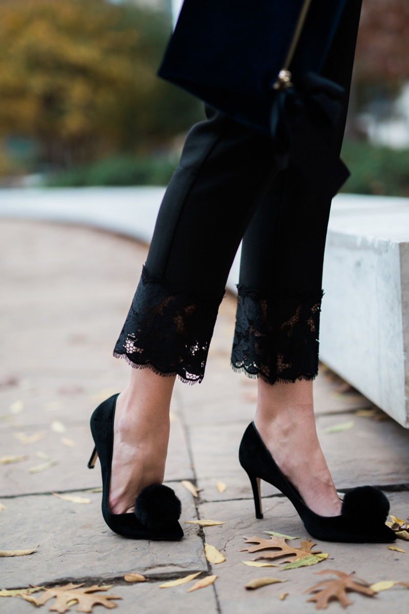 the miller affect wearing black pom pom heels and black lace hem pants from Ann Taylor