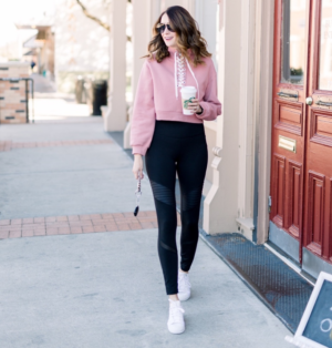 themilleraffect.com wearing a pink lace up pullover and black moto leggings