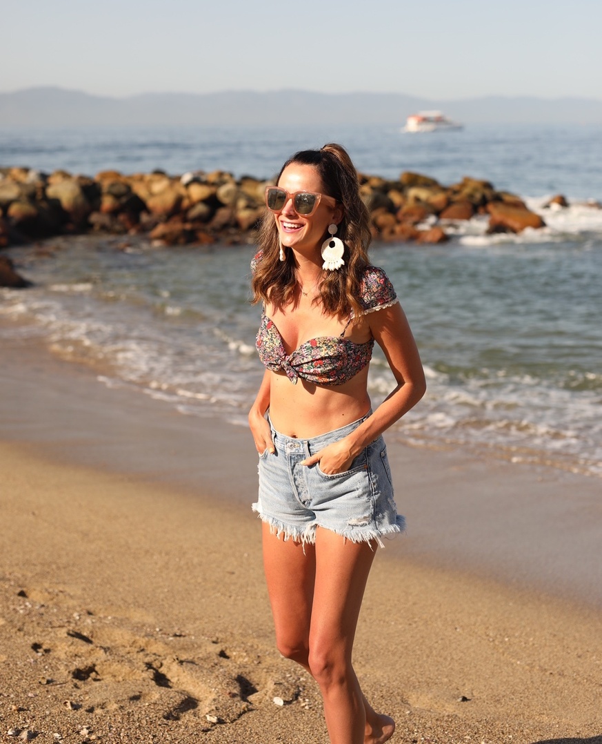 themilleraffect.com wearing a floral swim top and denim shorts