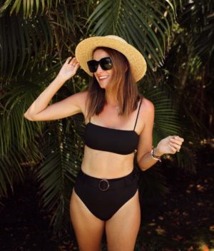 the miller affect wearing a black high rise two piece swimsuit in mexico