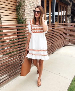 the miller affect wearing a white embroidered free people dress