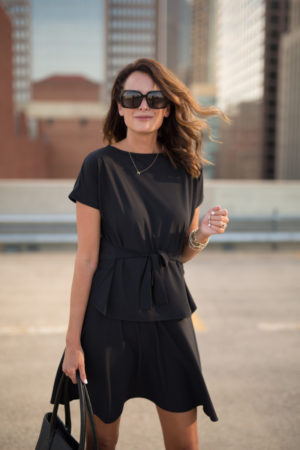 themilleraffect.com wearing black sunglasses and a black workwear dress